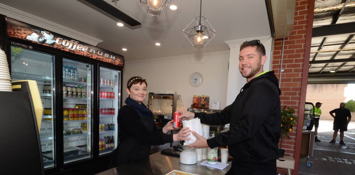 JOBS CREATED: Rachel King serves Kane Rodger at the new drive, ride and walk-in coffee shop at the old Kelly's Hotel site. Photo: JUDE KEOGH