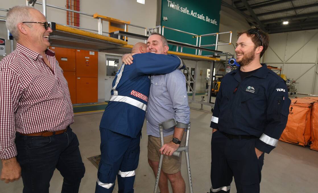 LIFE SAVER: Sean Moran (left) and Kylle Fenton watch as Jay McNabb hugs paramedic Peter Wiggins at the Orange air ambulance base. Photo: JUDE KEOGH
