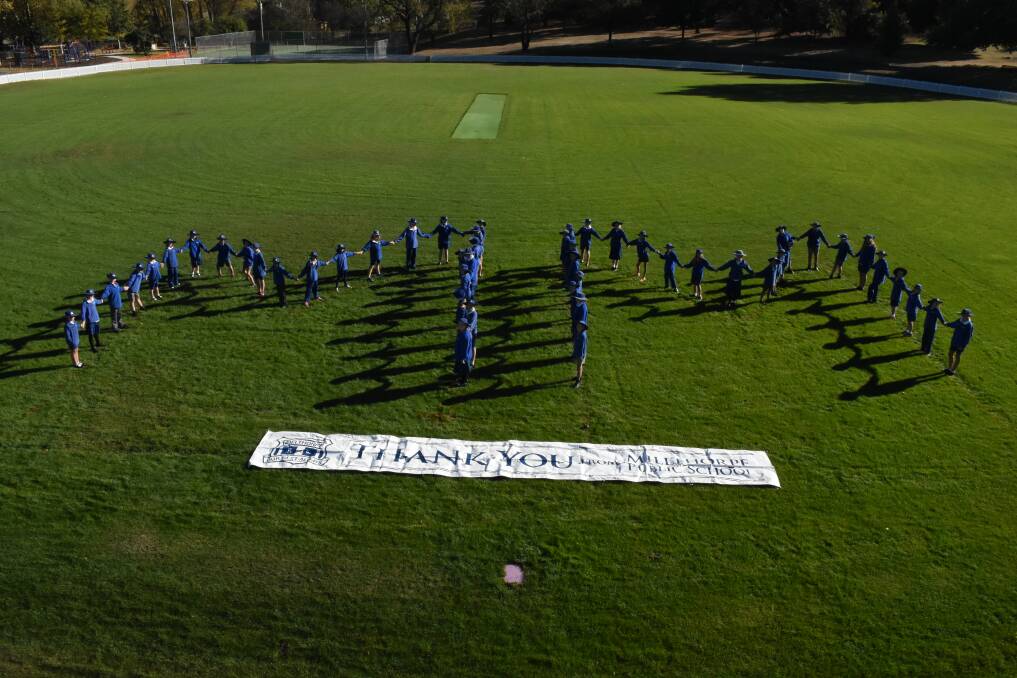 READY TO GO:  Millthorpe Public School students form a set of big Ms on Redmond Oval on Tuesday morning. Photo: MARK LOGAN