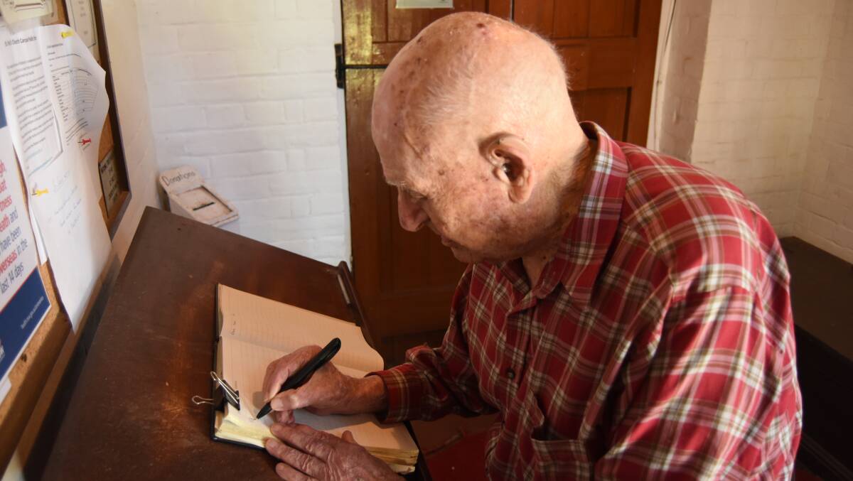 BACK ON THE BOOKS: Peter Icely signing the guest book at St Paul's. 