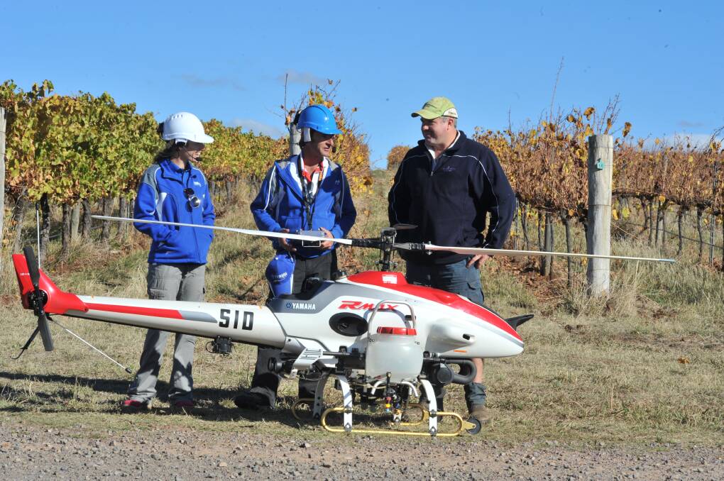 SKY TRIAL: Lauren Goddard, Phil Chadd and Tamburlaine vineyard manager Clayton Kiely testing the capabilities of the Yamaha Rmax helicopter in 2016. 
