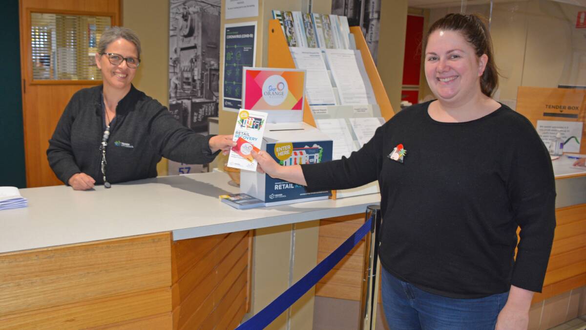 WINNER: Orange City Council customer service officer Sally-Lea Bilby handing Joanna Stewart a $50 gift to spend in Orange. Photo: SUPPLIED 