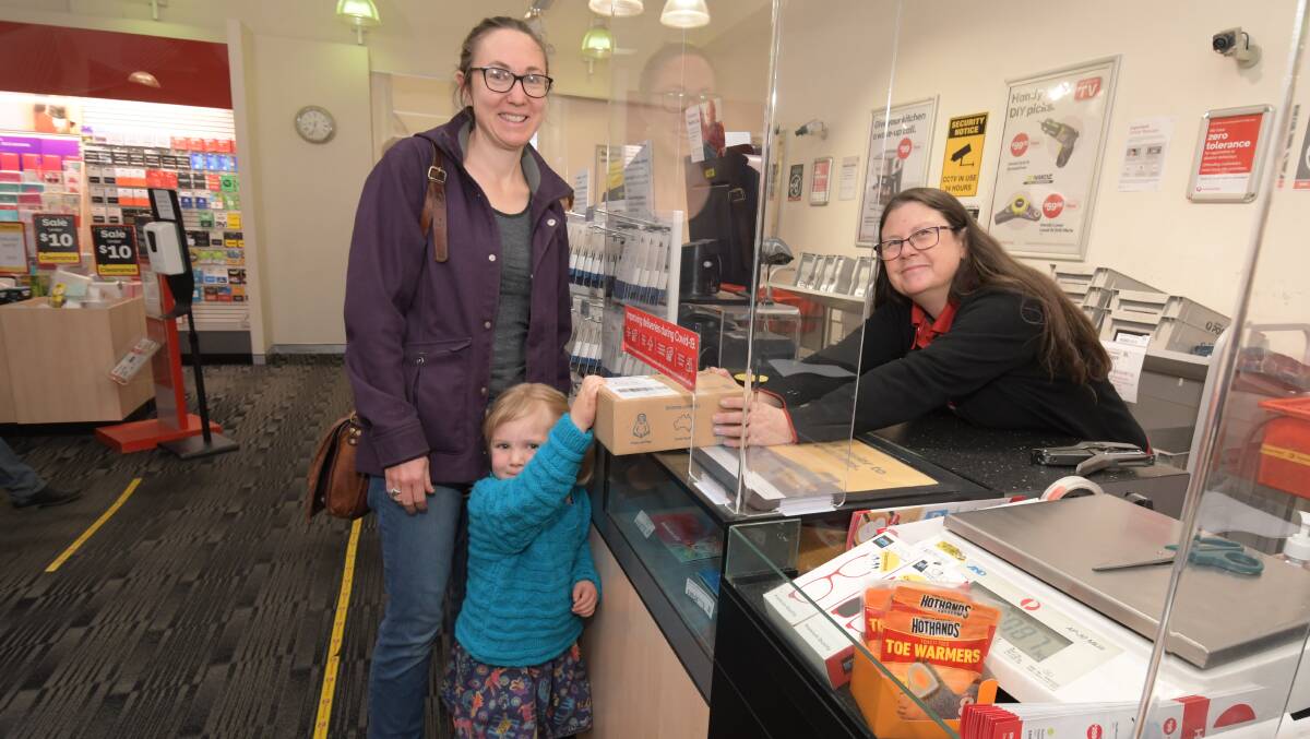 COLLECTING PARCELS: Orange Summer Street post office customers Bonny Campbell and Eliza Culverson collects a parcel from postal services officer Sharon White . Photo: JUDE KEOGH