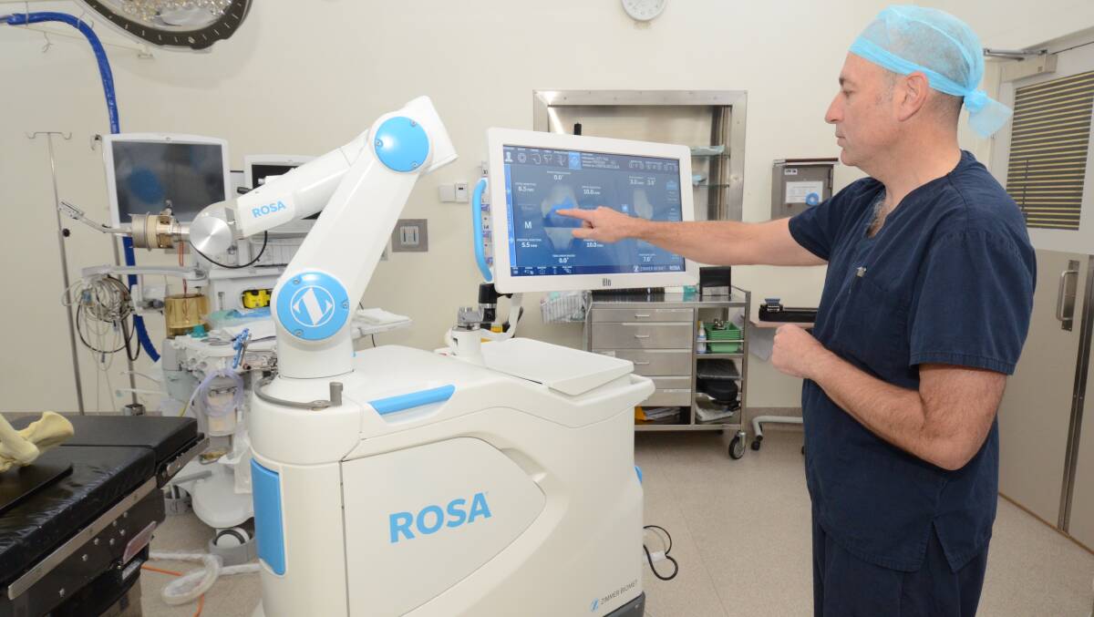 NEW TECHNOLOGY: Orthopaedic surgeon Dr Evan Jones demonstrates how medical professionals use the ROSA robot at the Dudley Private Hospital. Photo: JUDE KEOGH