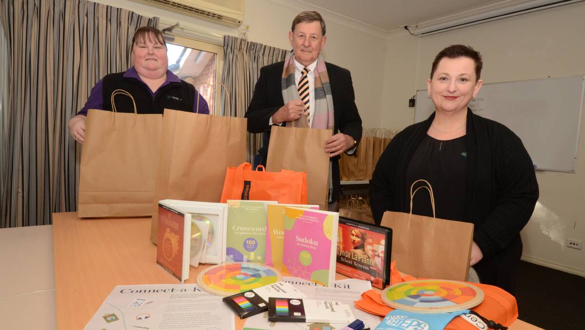 STAY CONNECTED: Orange City Council's community services development officer Amanda Rodwell, mayor Reg Kidd and community development team leader Julie Proctor prepare Connect-a-Kit for seniors. Photo: JUDE KEOGH