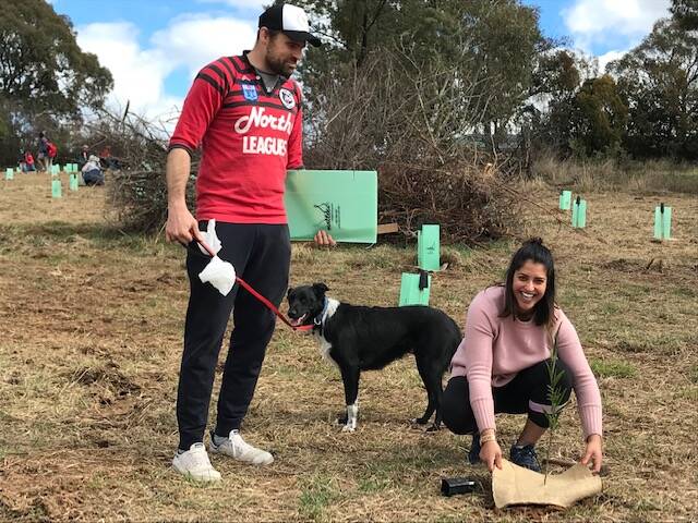 DIGGING DEEP: Nick and Mel Hughes-Clapp, and their dog Lenny, at the tree planting at Lake Canobolas reserve. Photo: CONTRIBUTED 