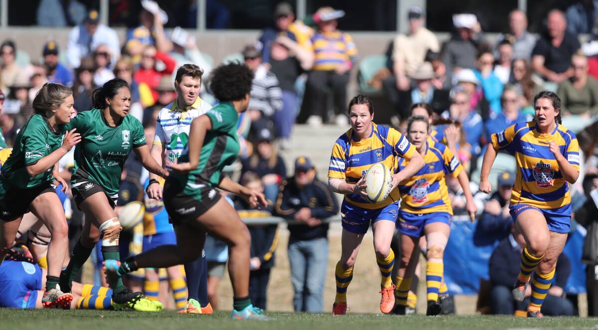 BUMPER CROWD: Mandy Scott looks to shift the ball left in front of a big crowd during the first grade final of the day on Saturday. Photo: PHIL BLATCH