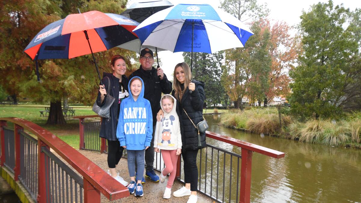 UMBRELLA OUT: Laura, Molly, Jon, and Grace Pitcher, Olivia Battye at Cook Park throughout what was a wet end to April in Orange. Photo: JUDE KEOGH