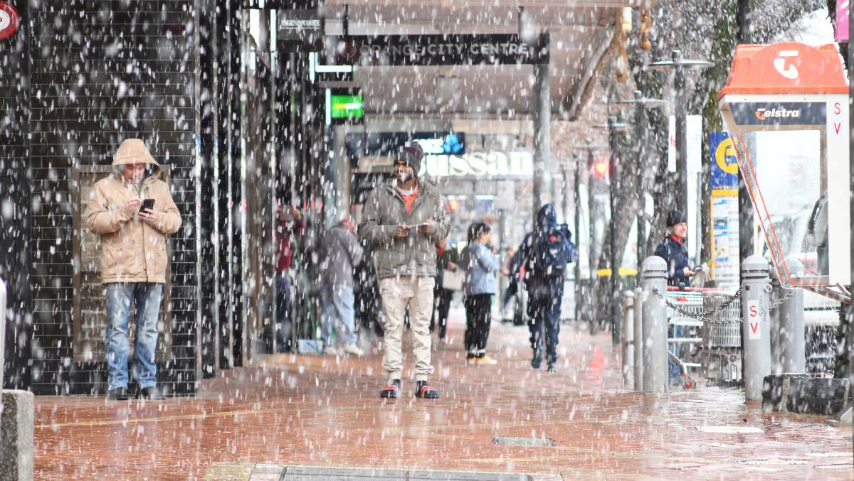 Summer Street pedestrians take cover in 2021 as heavy snow fell in the CBD. We could see similar falls on Friday morning, with a top of 5 degrees on the radar. Picture by Jude Keogh.
