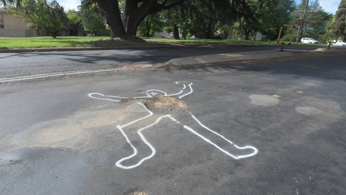 A man-shaped outline has appeared on Burrendong Way, the drawing surround a pothole. Photo: CARLA FREEDMAN