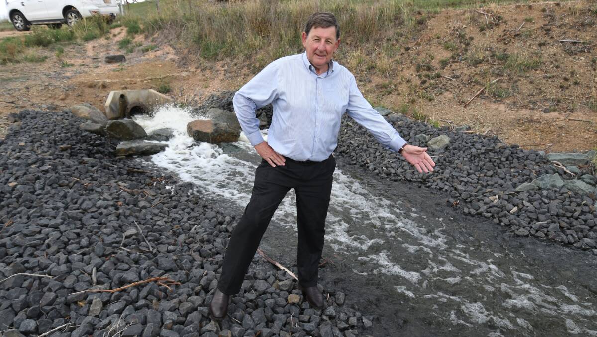 DOING THE TRICK: Mayor Reg Kidd near the flow from the working Macquarie River Pipeline, which has helped boost Orange's water storage this week. Photo: JUDE KEOGH