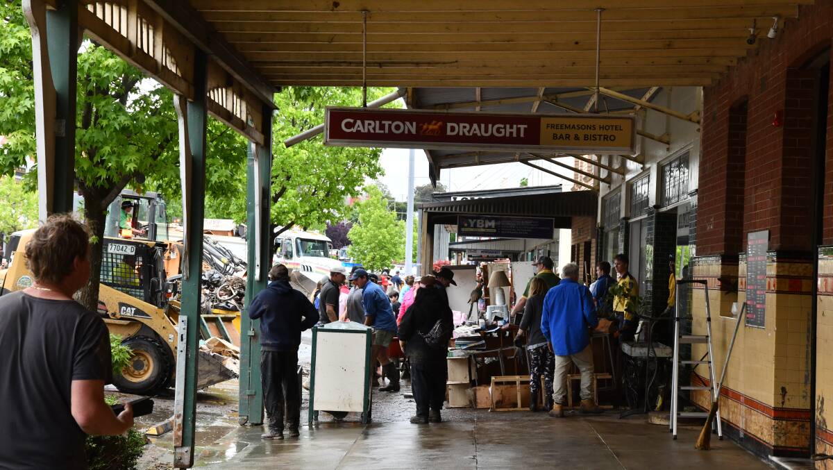 People in Molong flock to aid the clean-up effort after Monday's flood. Picture by Carla Freedman.