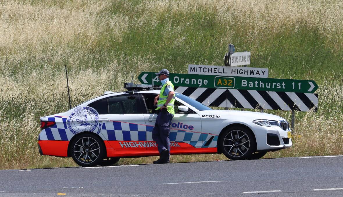 Police at the road block diverting traffic from the scene. The Mitchell Highway is expected to remain closed into Monday afternoon. Photo: Amy Rees