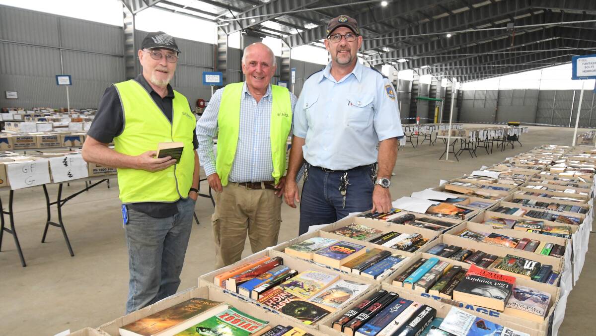 BOOK IT IN: Garry Sewell, Alex Ferguson and Scott Keen setting up for the weekend's book fair. Photo: JUDE KEOGH