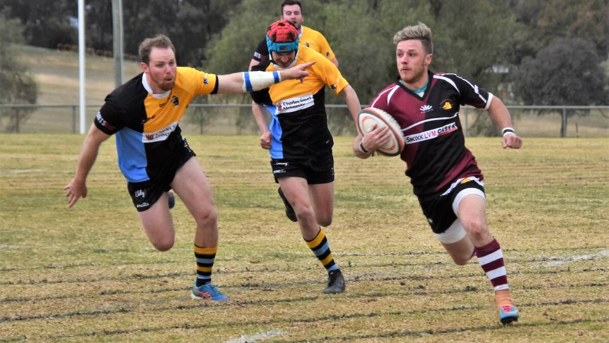 ROUND THE OUTSIDE: Parkes' Lloyd Rogers scoots around the CSU Bathurst defence during last week's preliminary final at Northparkes Oval. Photo: JENNY KINGHAM