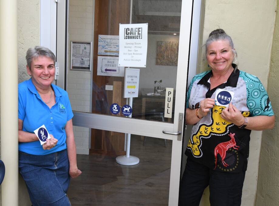 ACCESS AWARENESS: Prue McCarthy and Central West Ability Links team leader Margi Garretty with some of the stickers at Cafe Connect. Photo: JUDE KEOGH