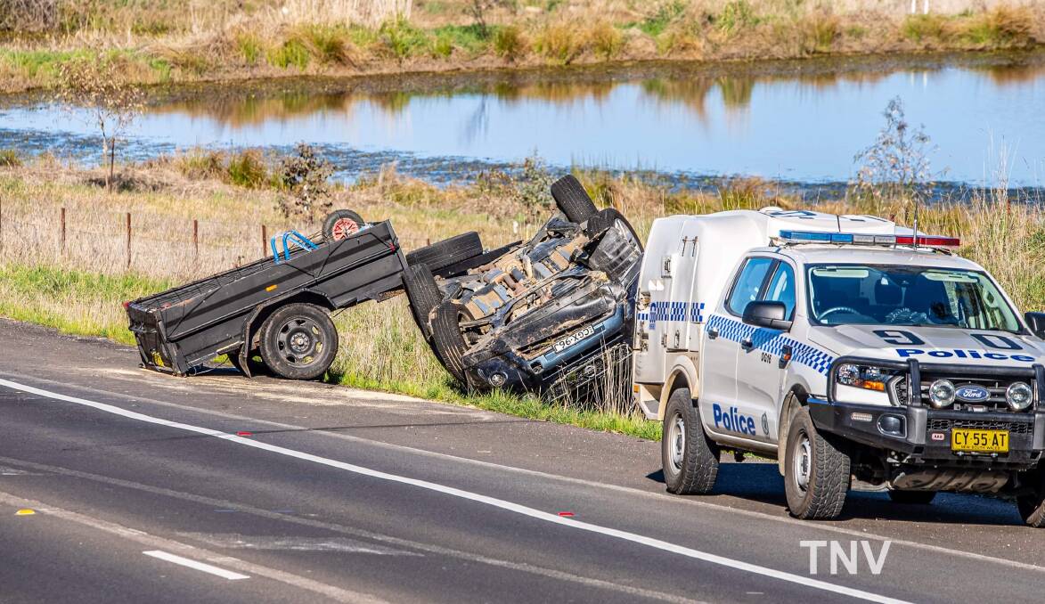 CRASH: A car towing a trailer rolled onto its roof on the Northern Distributor on Wednesday morning. Photo: TROY PEARSON
