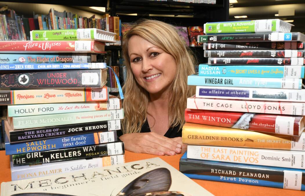 POPULAR ITEMS: Orange City Library librarian Tammy Wilson with some of the children's and adult books and DVDs people borrowed the most in 2018. Photo: JUDE KEOGH