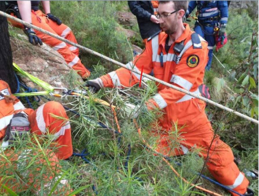 HELPING HAND: SES volunteer Zack Schneider assists in extracting a teenager from Mount Canobolas. Photo: SES