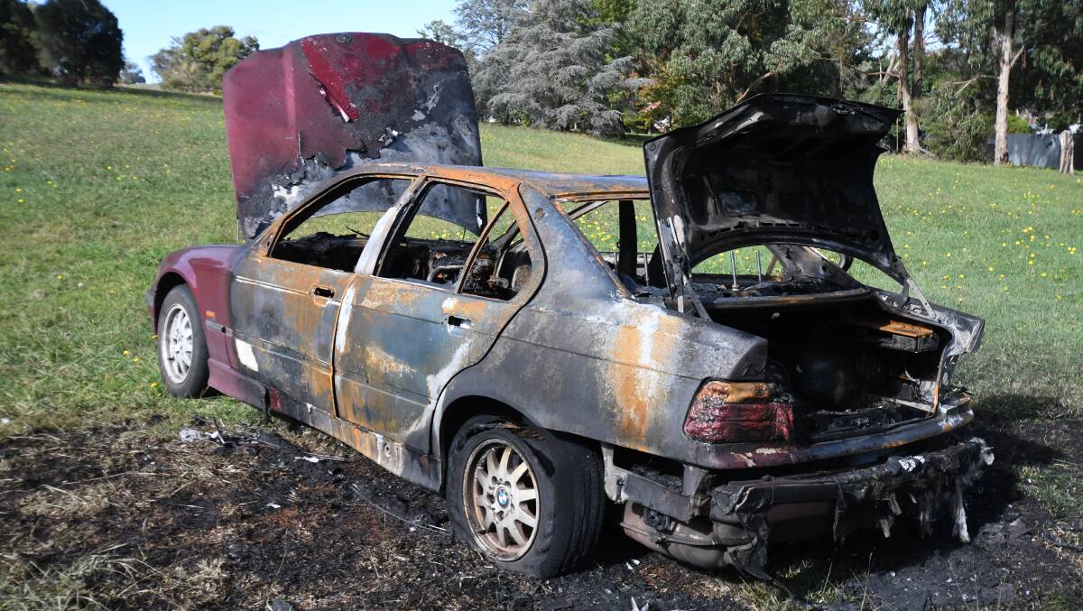 BURNT OUT: A stolen BMW was dumped and torched in a park in east Orange in April. Photo: JUDE KEOGH