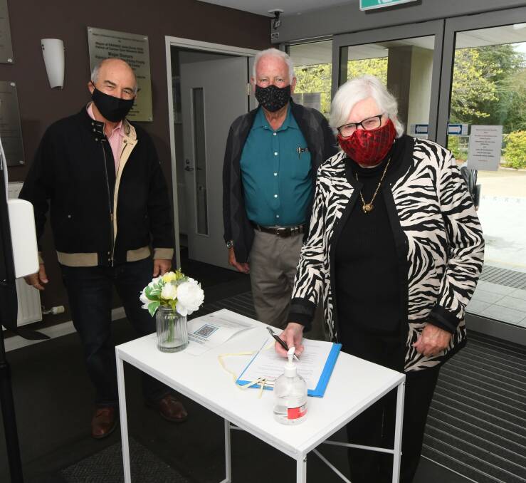 GUEST SAFETY: John Carpenter, John and Roslyn Rennick sign in at Western Care Lodge. Photo: JUDE KEOGH