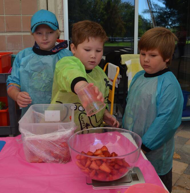 TEAMWORK: Brothers Christian, Lucas and Mason Coles worked together to make fruit cordial with strawberries on Friday. 