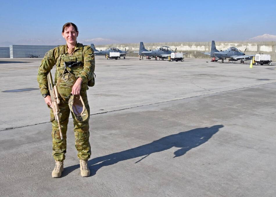 ANZAC HONOUR: Royal Australian Air Force officer Squadron Leader Melanie Keir at Hamid Karzai International Airport, Afghanistan. Behind her are three Afghan Air Force Embraer A-29 Super Tucano counter-insurgency aircraft. Photo: SUPPLIED 