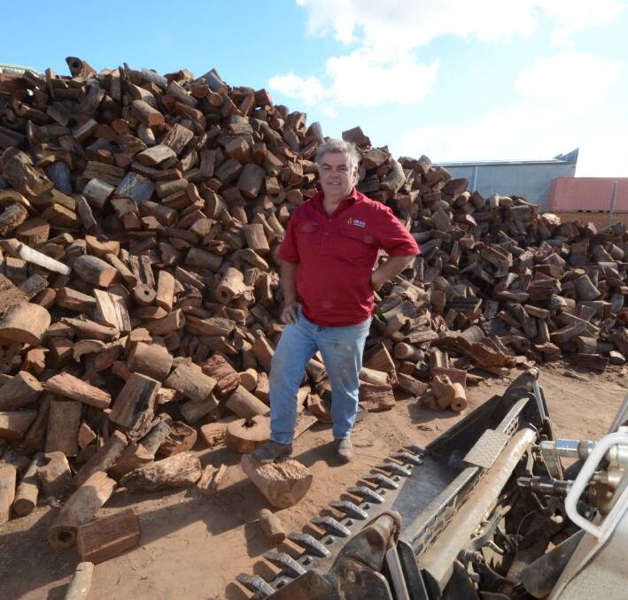 WINTER FUEL: Ablaze Firewood owner Andrew Gordon with his wood pile said orders started earlier this year due to an earlier onset of cold weather. Photo: JUDE KEOGH