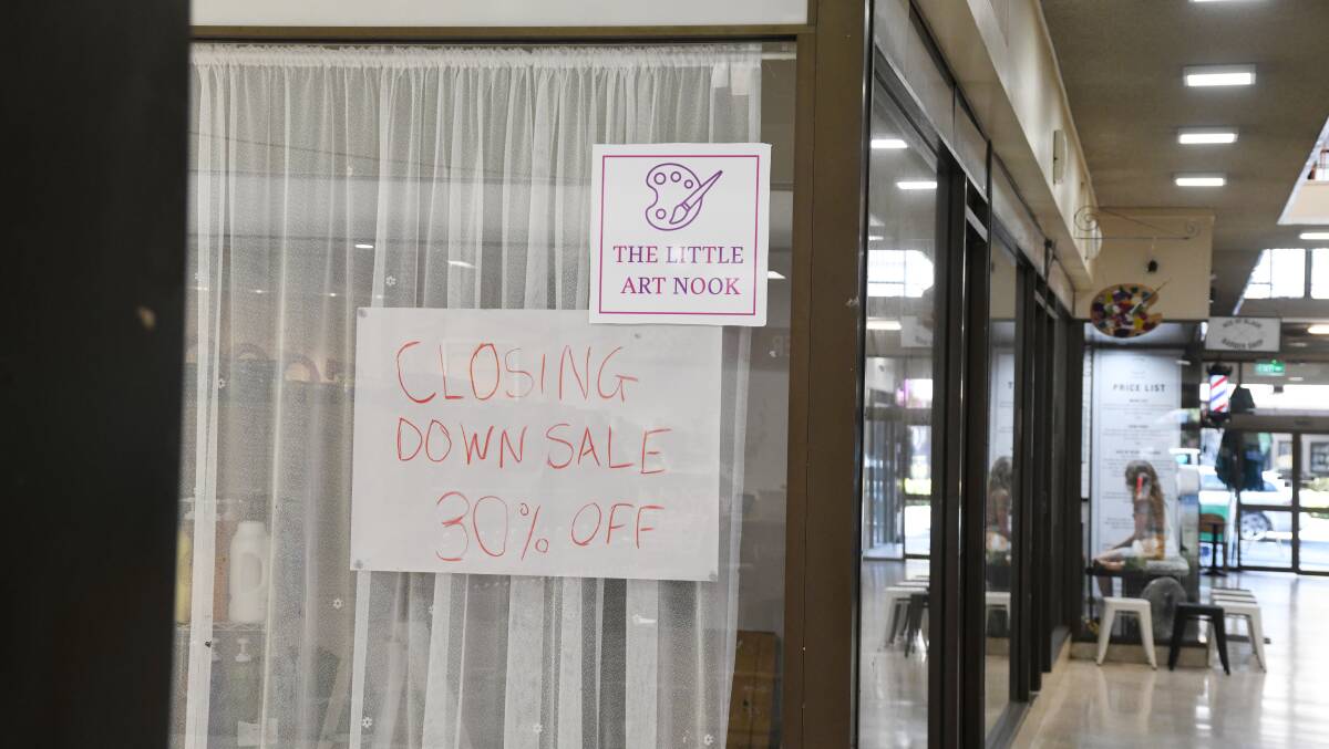 A sign indicating the closure of The Little Art Nook in the Orange Arcade. 