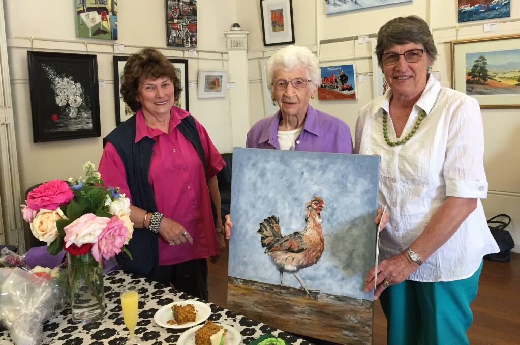 MILESTONE: Wanda Driscoll, centenarian Daphney Meyer holding a picture of a rooster she painted and her daughter Cheryl Lobsey. Photo: TANYA MARSCHKE