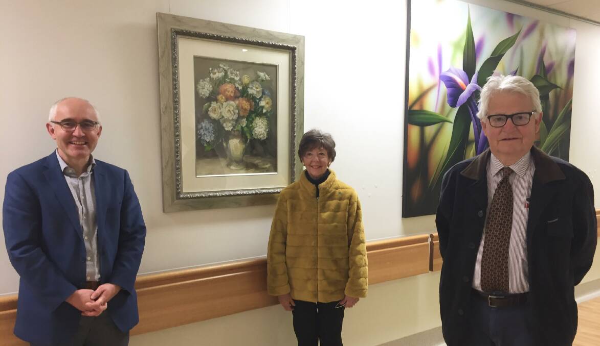 GENEROUS: Central West Cancer Services head of cancer services Dr Rob Zielinski, artist Loretta Blake and Roger Ellis who donated the painting. Masks removed for photo.
