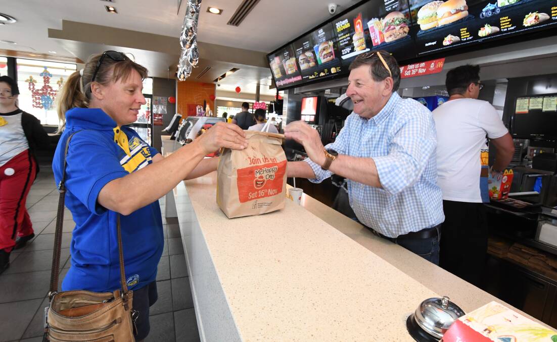 PAY RATES: Mayor Reg Kidd serves Amanda Wiegold during McHappy Day at McDonald's. Photo: JUDE KEOGH.