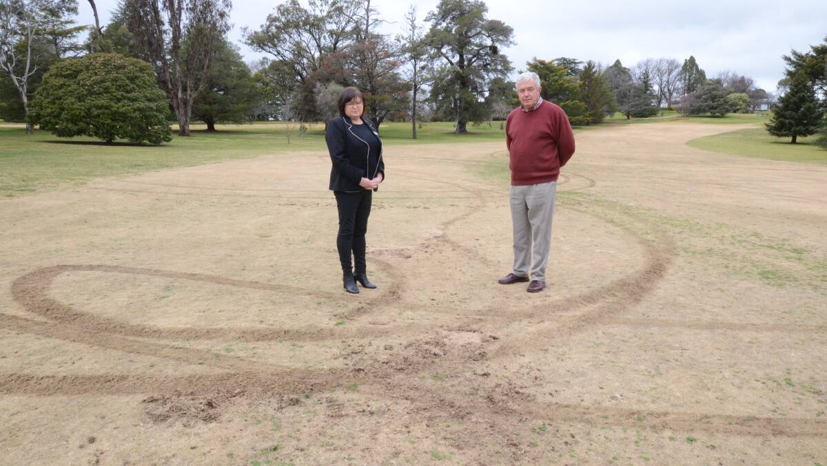 KEEP OFF THE GRASS: Duntryleague's John Cook and Michelle Carroll were disappointed at golf course damage caused by vandals in February. Photo: JUDE KEOGH.