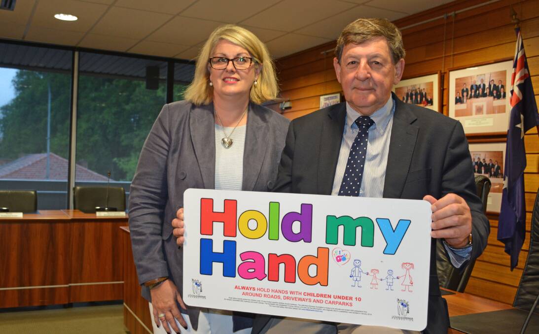  

SAFETY : Michelle McLaughlin from the Blue Dinosaur Foundation shows Orange mayor Reg Kidd one of the signs to be installed in local parks throughout Central West NSW. PHOTO: SUPPLIED.
