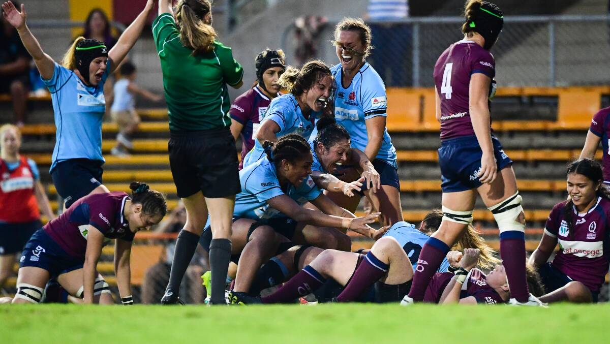 CHAMPIONS: The NSW Waratahs mob Grace Hamilton after she scored the match-winner in last weekend's Super W decider. Photo: RUGBY AU MEDIA/STUART WALMSLEY