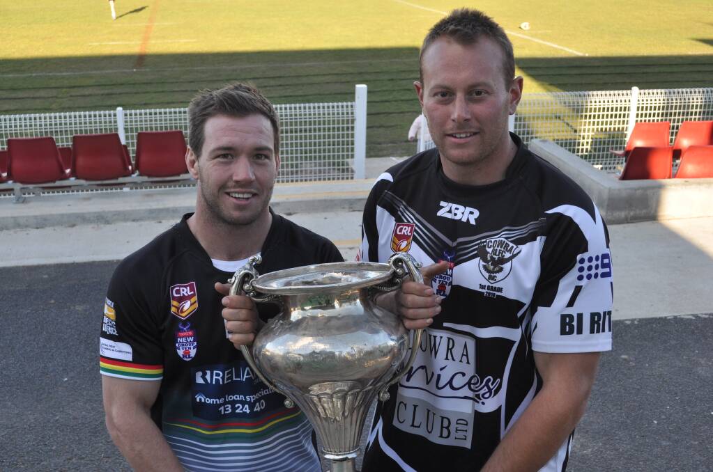 ONE HAND ON THE PRIZE: Panthers skipper Doug Hewitt with Cowra captain Josh Rainbow and the Western Challenge Cup, the prize for winning the Group 10 premier league competition. Photo: NICK McGRATH