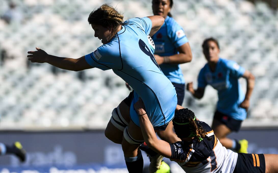 DOUBLE TROUBLE: Waratahs No.8 Grace Hamilton tries to break a tackle on her way to a brace in NSW's first-round win over the ACT. Photo: DION GEORGOPOULOS