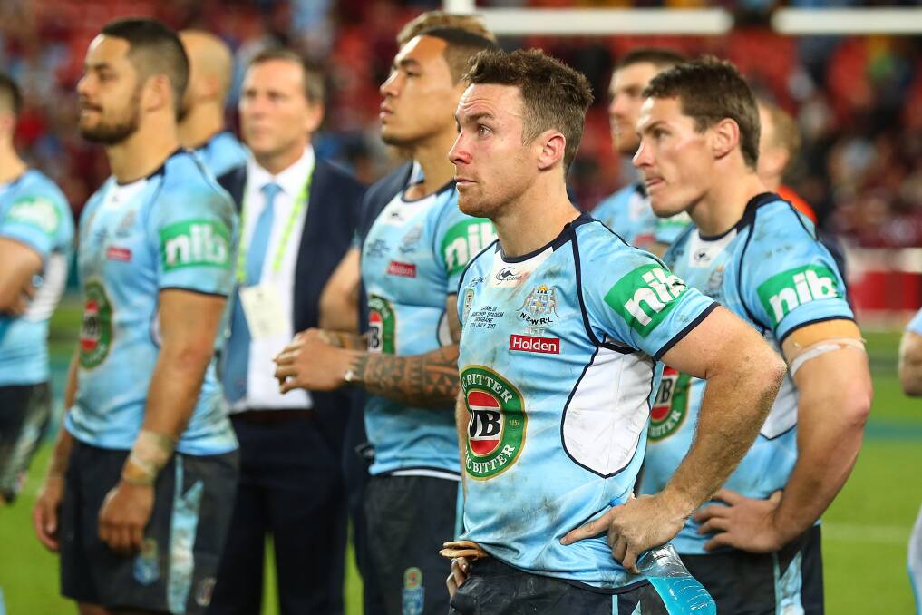 HORRIBLE: Orange-born NSW five-eighth James Maloney watches on as Queensland skipper Cameron Smith accepts the State of Origin shield, again. Photo: GETTY IMAGES