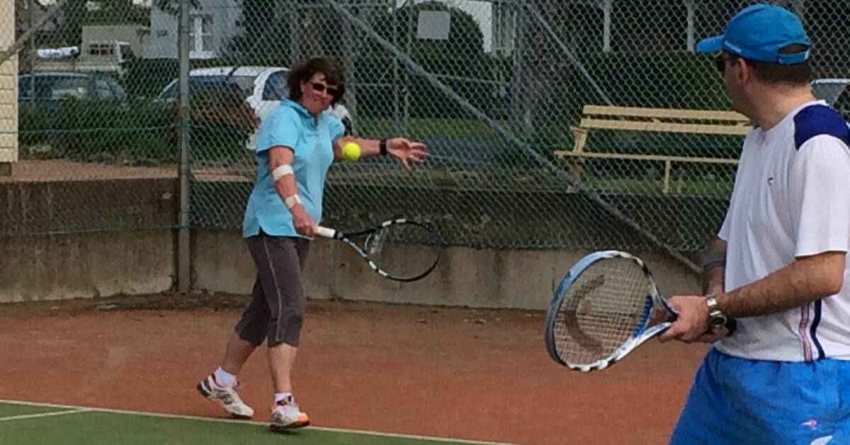 BACKHAND: Kathy Penrose whacks one while her partner Brett Campbell watches on during last Sunday's mixed social competition. Photo: CONTRIBUTED