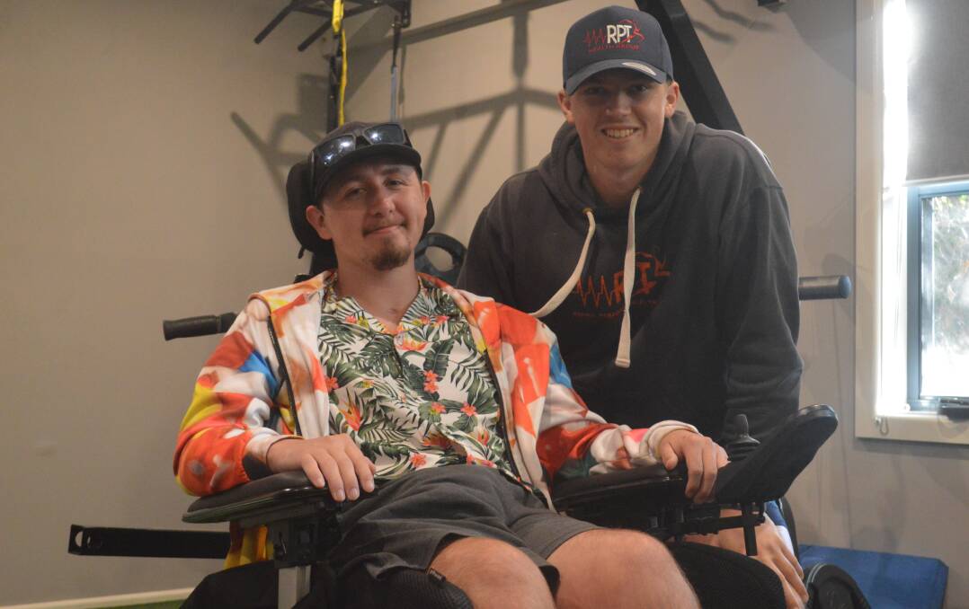 POSITIVITY: Michael Brennan gives a smile before hitting the gym with RPT Health Group's Fletcher Wright, a story of determination himself. Photo: MATT FINDLAY