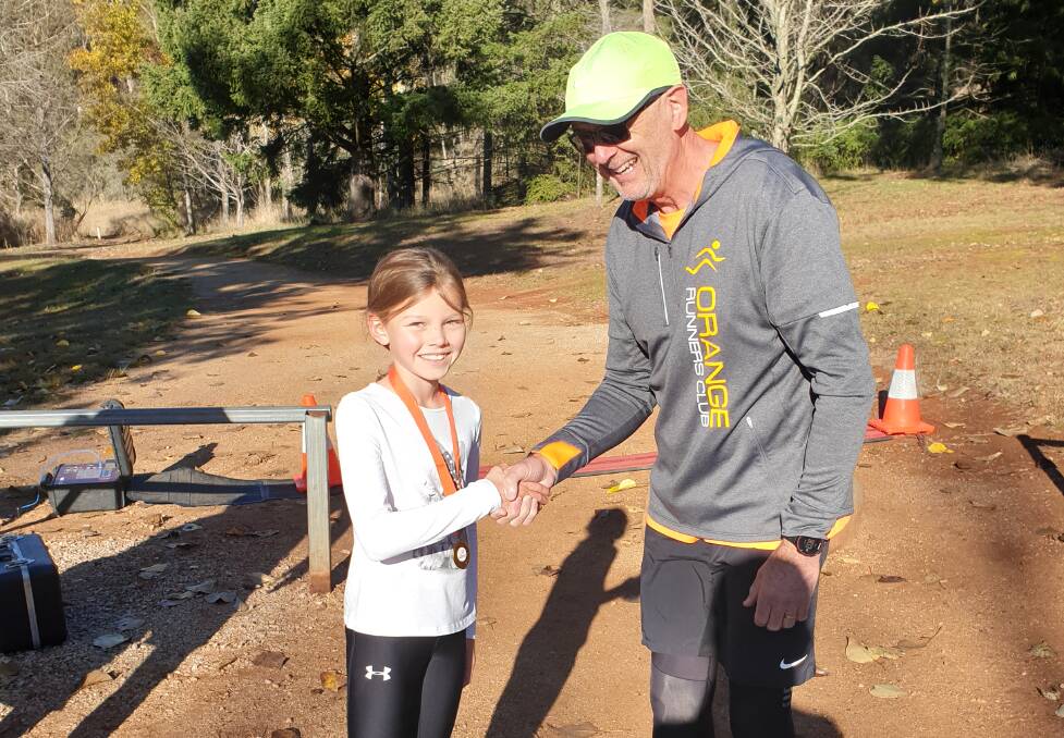 SPEED TO BURN: Grace Hosie is presented with a medal for achieving 50 club runs by vice president Greg Shapter, and then she proceeded to be the fastest female over the one lap 2.5km course at Lake Canobolas. Photo: CONTRIBUTED