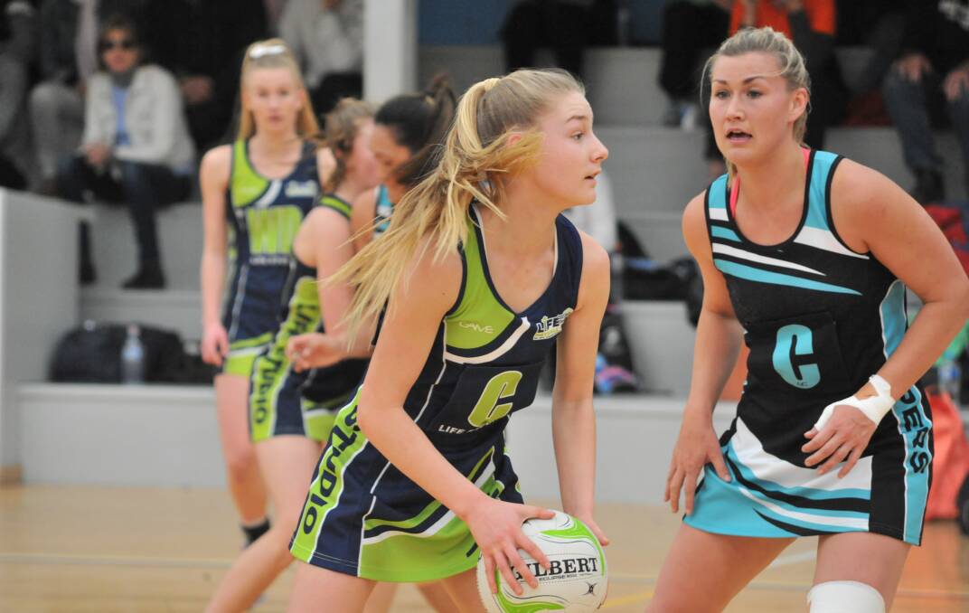 PAST AND PRESENT: Annie Miller in action for Life Studio on Saturday, with former Australian Schoolgirl Sophie Fardell (right) keeping a close eye on her. Photo: JUDE KEOGH 0806jknetball7