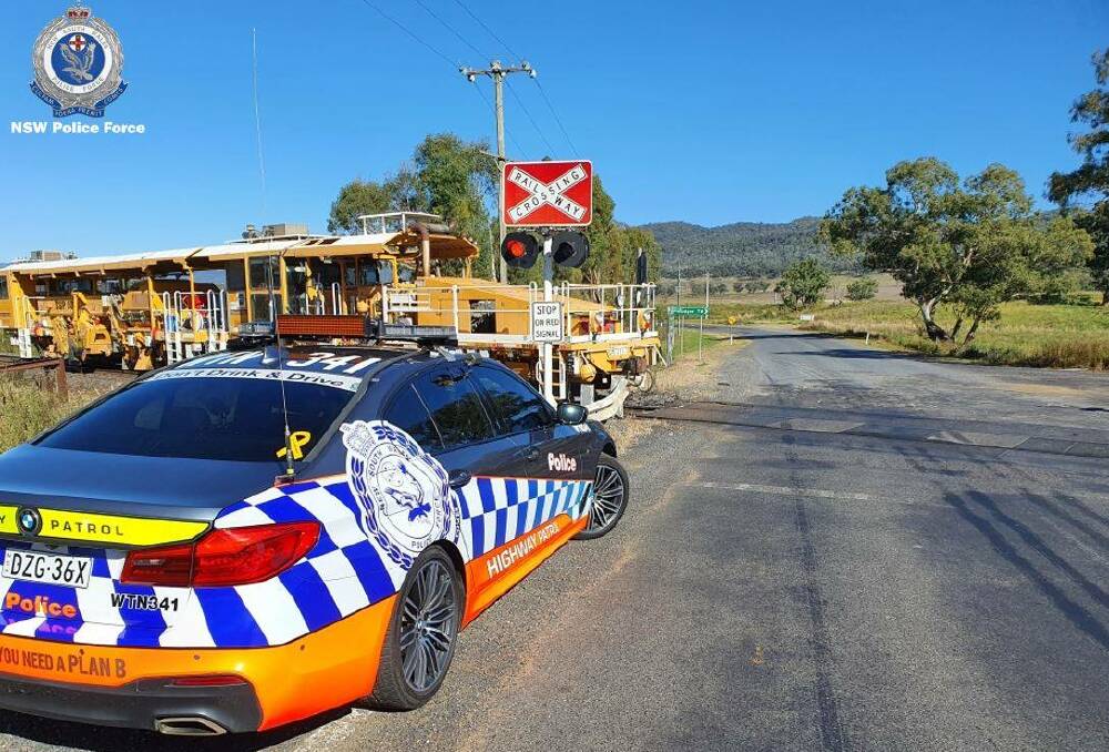FOCUS: A highway patrol car at a level crossing on the Bylong Valley Way, police will target dangerous driving at level crossings this week. Photo: NSW POLICE FORCE