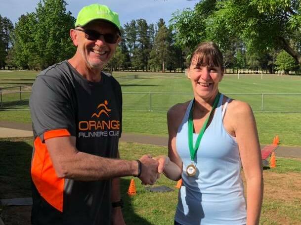 MILESTONE: Orange Runners Club vice president Greg Shapter presents Tanya Connolly with her 600-run medal. Photo: CONTRIBUTED