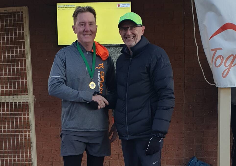 MAMMOTH MILESTONE: David Craig is presented with his medal for 700 runs by Orange Runners Club vice president Greg Shapter. Photo: CONTRIBUTED