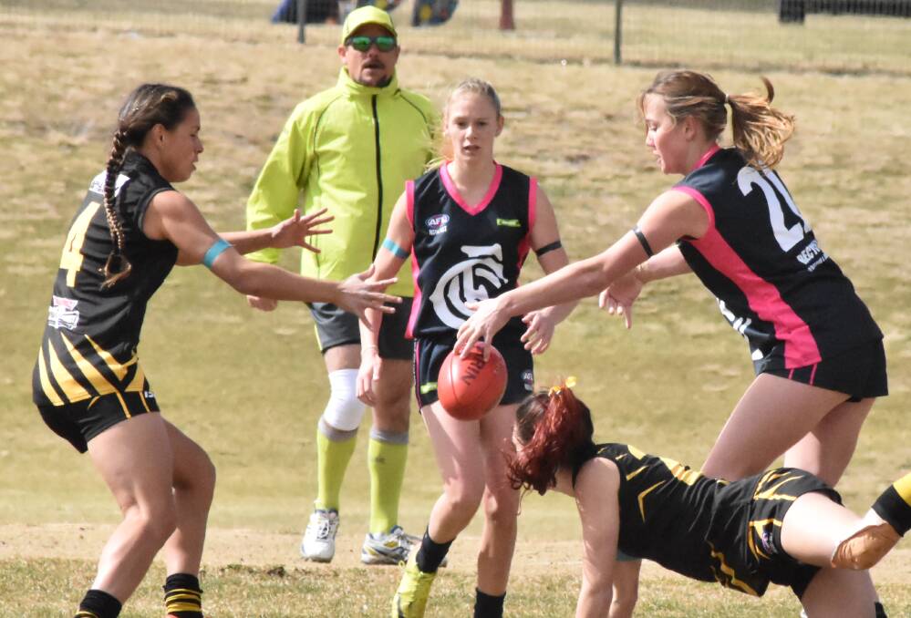 MIDFIELD BATTLE: Orange's Erin Naden (left) looks for a clearance in Saturday's minor semi-final victory over Cowra. Photo: SHARON MALONEY