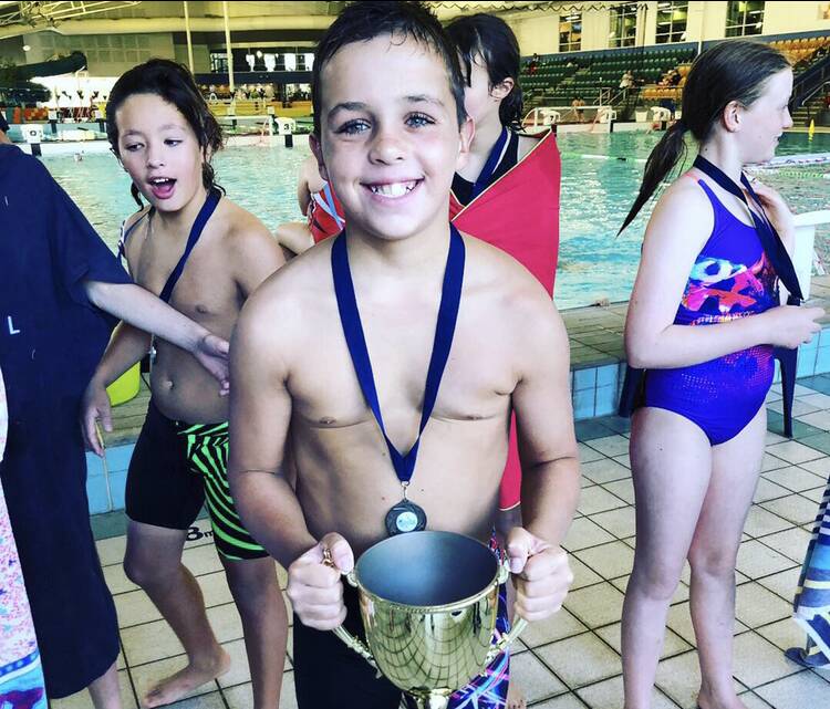 CHAMPION: AJ Logan proudly shows off his side's Waterpalooza trophy, the youngster's encouraged any other juniors to try the sport out. Photo: CONTRIBUTED