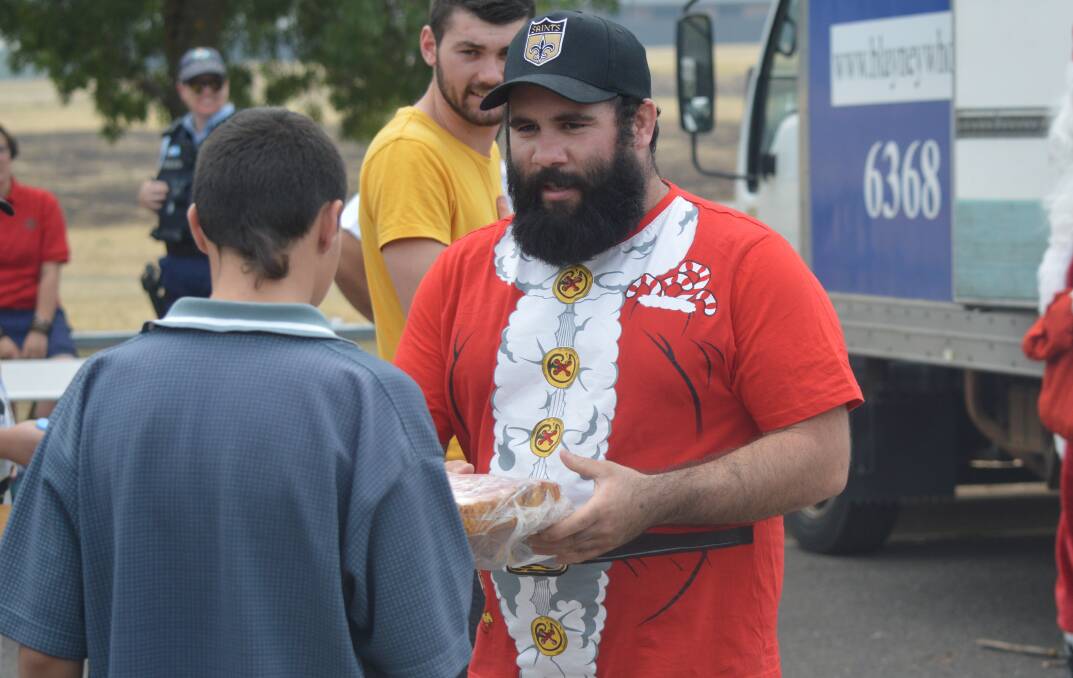 GRATEFUL: Tom Goolagong hands out a ham during Christmas Eve's food drive, with almost a tonne delivered across Orange. Photo: MATT FINDLAY