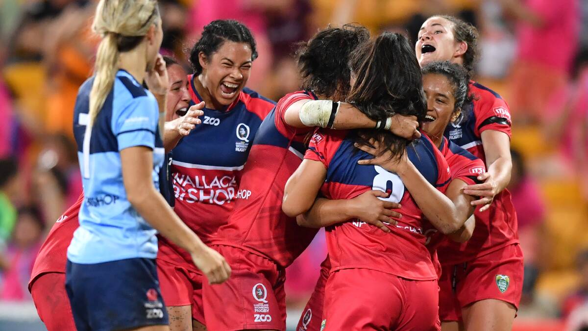 THE TITLE-WINNER: Queensland players envelop 17-year-old Alysia Lefau-Fakaosilea after she scored the winning try at the Brisbane Global Rugby Tens. Photo: AAP/DARREN ENGLAND