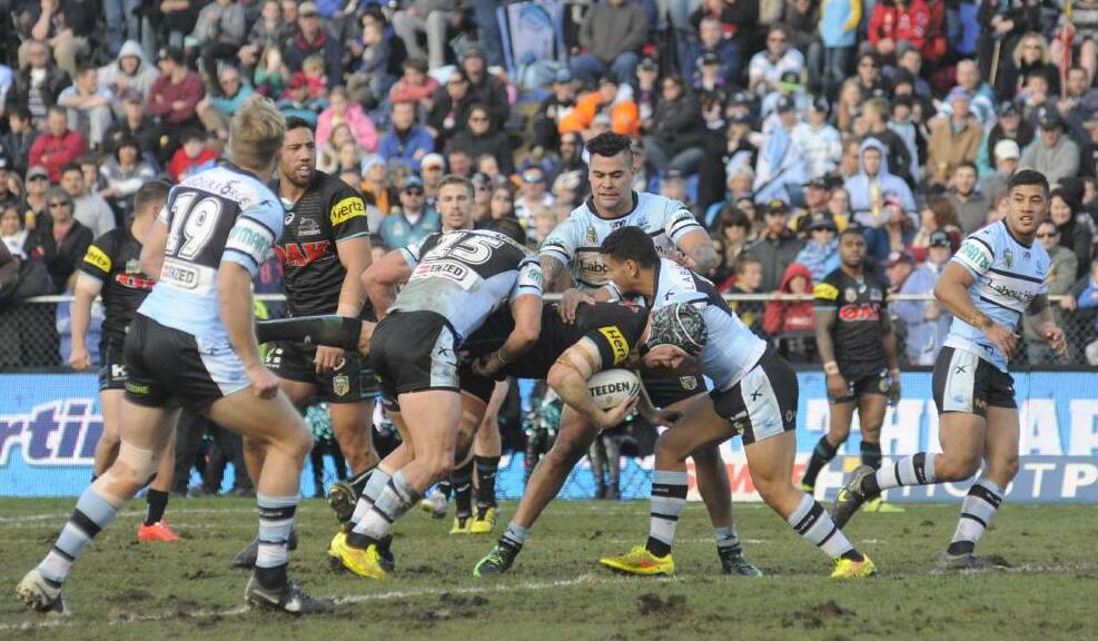 SHARK ATTACK: Penrith Panthers and Cronulla Sharks playing on a heavy surface at Bathurst's Carrington Park in 2014. Photo: CHRIS SEABROOK